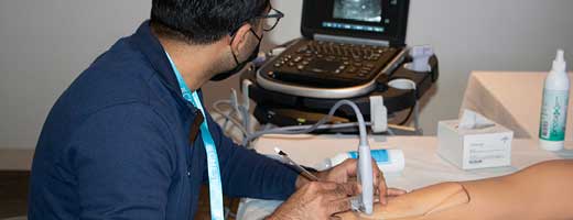 A person practicing ultrasonography on a manikin