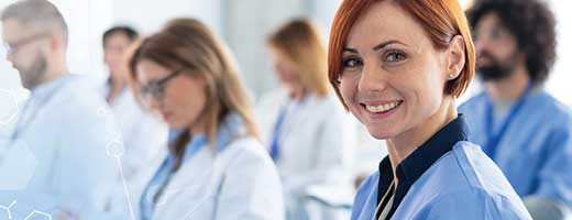 A woman in blue scrubs smiles