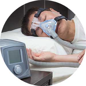 A man on a hospital bed undergoing noninvasive mechanical ventilation