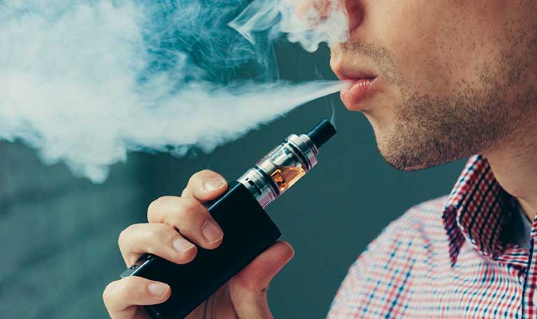 A person exhales after using an electronic cigarette