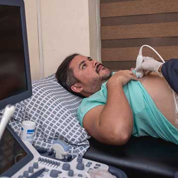 A doctor performs a thoracic ultrasound procedure on a male patient